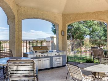a patio with a grill and tables and chairs at Links at High Resort, Rio Rancho